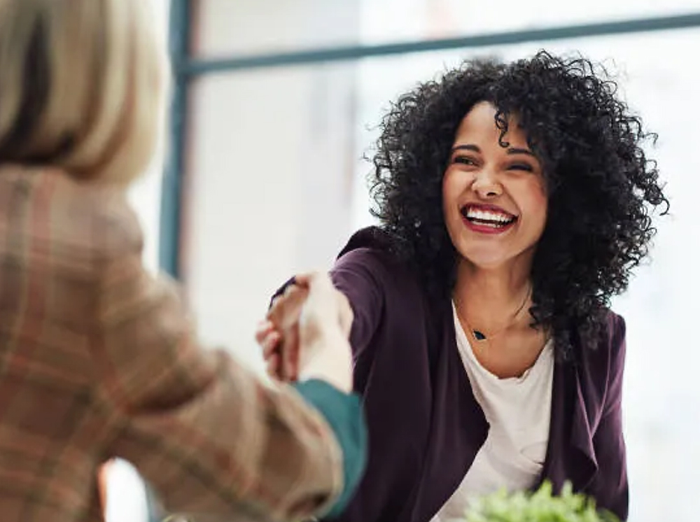 A new hire shakes hands with their new employer.
